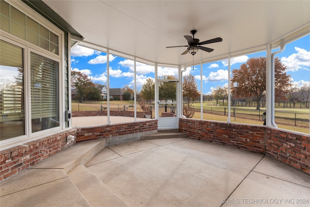 unfurnished sunroom with ceiling fan