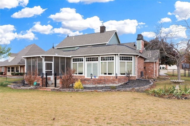 rear view of house with a sunroom and a yard