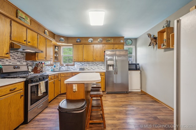 kitchen with tasteful backsplash, a center island, stainless steel appliances, and dark hardwood / wood-style floors