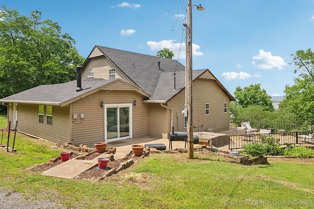 rear view of property featuring a yard and a patio