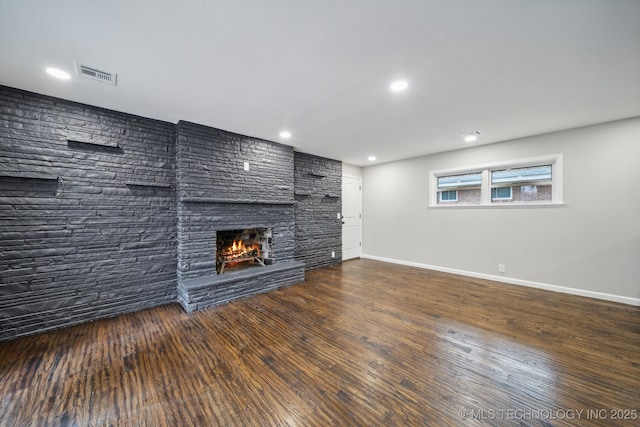 unfurnished living room with dark wood-type flooring and a fireplace