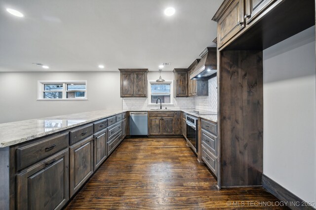 kitchen featuring sink, hanging light fixtures, decorative backsplash, stainless steel dishwasher, and kitchen peninsula