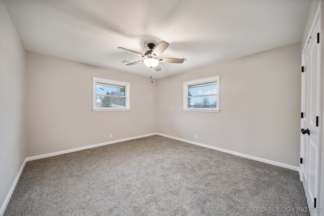 carpeted spare room with plenty of natural light and ceiling fan