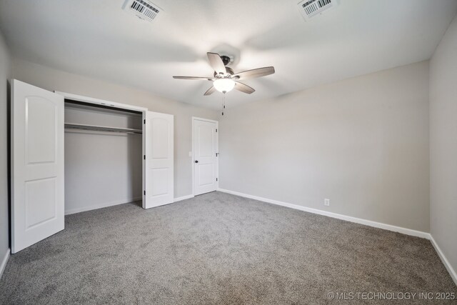 unfurnished bedroom with dark colored carpet, ceiling fan, and a closet