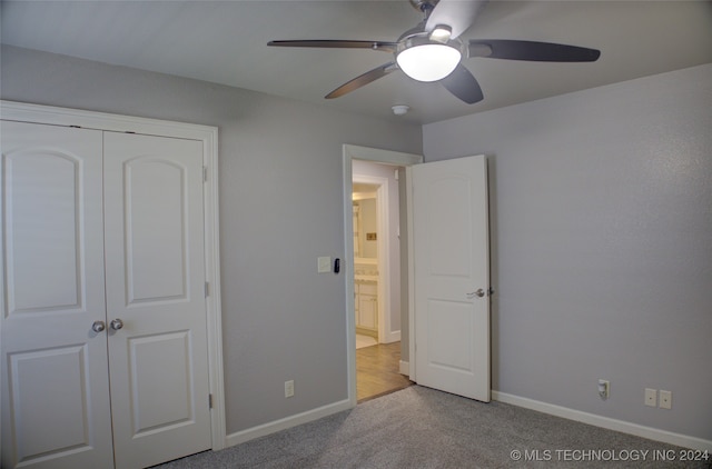 unfurnished bedroom featuring a closet, ceiling fan, and light colored carpet