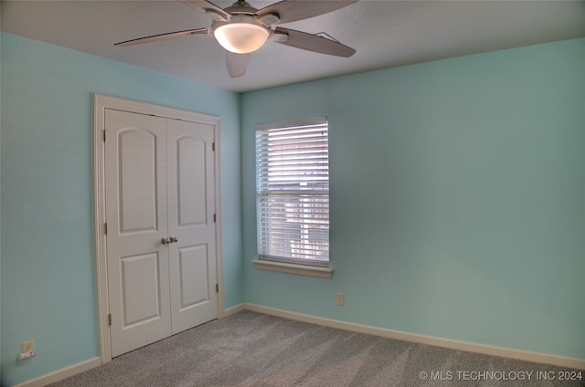 carpeted spare room with ceiling fan