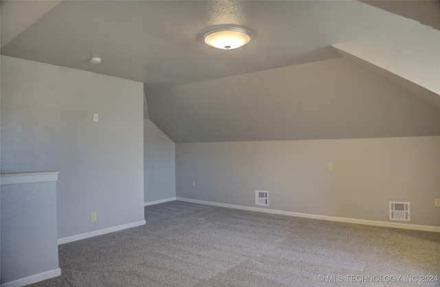 bonus room with carpet flooring and vaulted ceiling