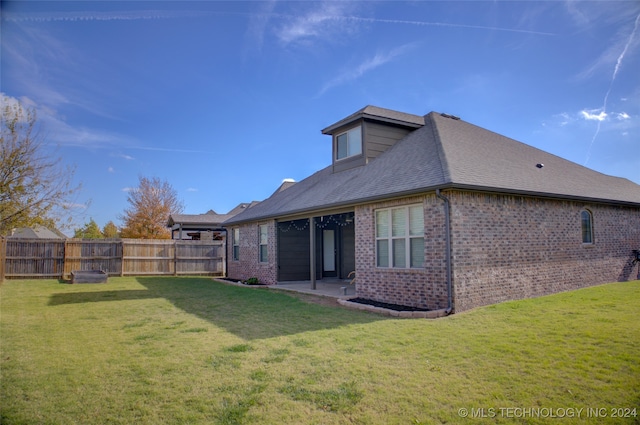 rear view of property featuring a patio area and a yard