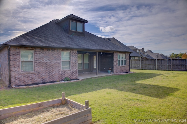 back of property featuring a patio area and a yard