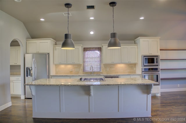 kitchen with light stone countertops, stainless steel appliances, dark hardwood / wood-style flooring, a spacious island, and pendant lighting