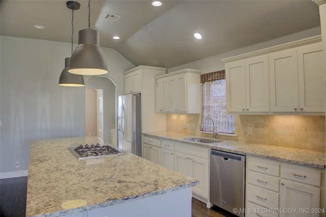 kitchen with sink, a center island, stainless steel appliances, decorative light fixtures, and lofted ceiling