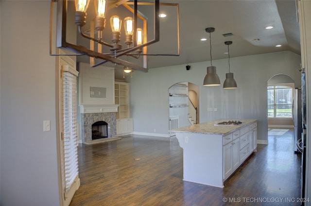 kitchen with white cabinets, pendant lighting, dark hardwood / wood-style floors, and light stone countertops