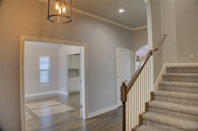 stairs featuring crown molding and wood-type flooring