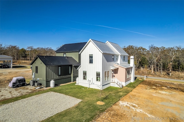 back of property with a lawn and cooling unit