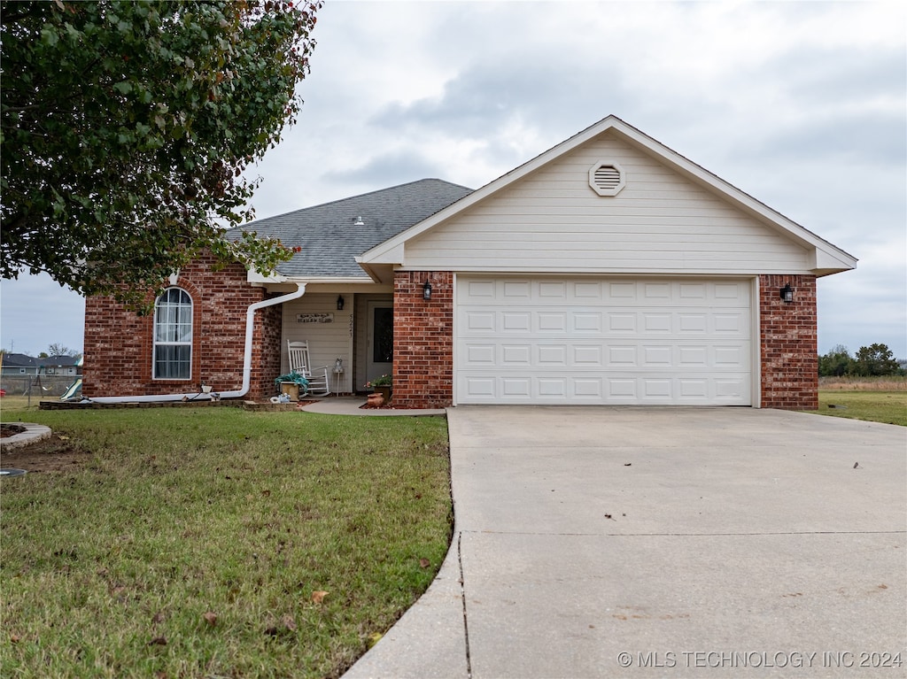 single story home featuring a garage and a front yard