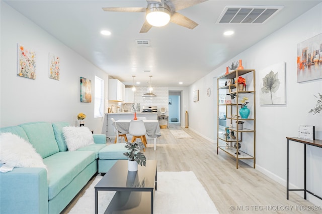 living room with light hardwood / wood-style flooring and ceiling fan