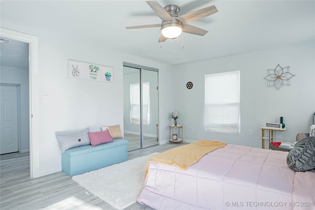 bedroom featuring ceiling fan, light hardwood / wood-style flooring, and a closet