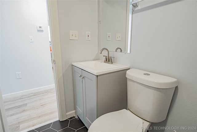 bathroom with hardwood / wood-style floors, vanity, and toilet