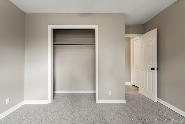 unfurnished bedroom with carpet floors and a closet