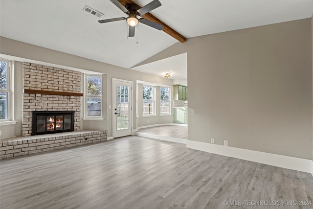 unfurnished living room featuring vaulted ceiling with beams, ceiling fan, a fireplace, and light hardwood / wood-style floors