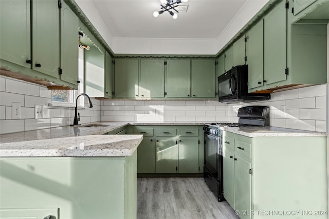 kitchen featuring sink, green cabinets, light hardwood / wood-style flooring, black appliances, and ornamental molding