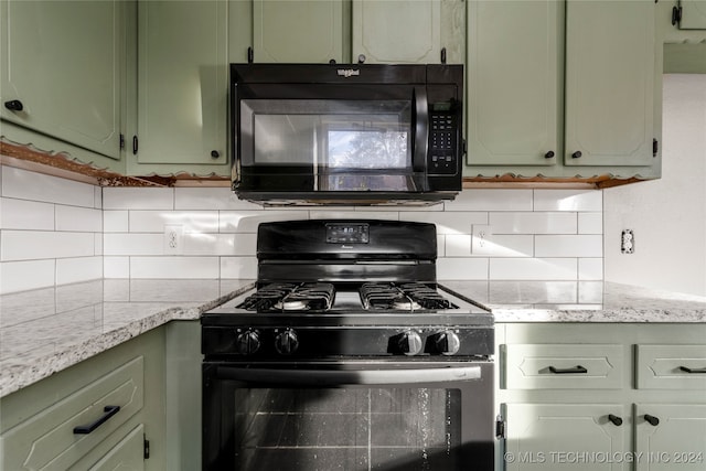 kitchen featuring black appliances, decorative backsplash, and green cabinetry