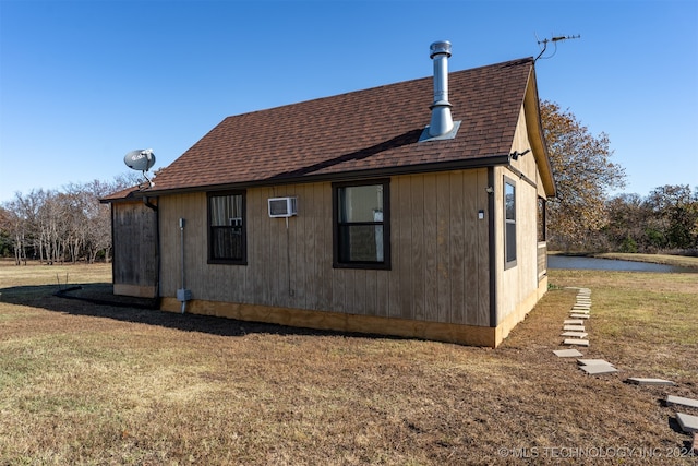 view of property exterior featuring a wall unit AC and a yard