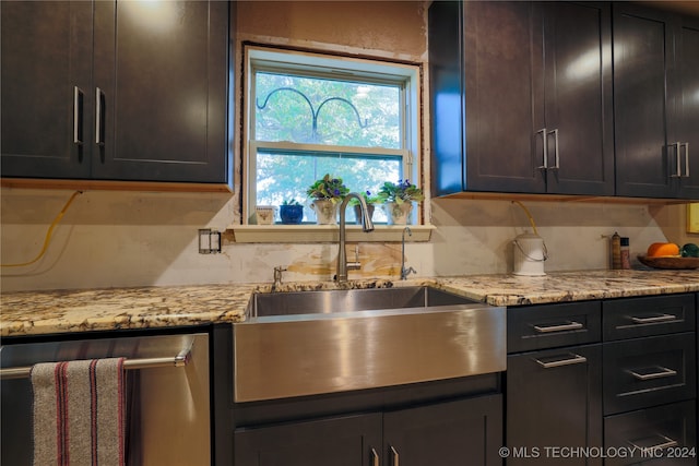 kitchen featuring light stone countertops, backsplash, dark brown cabinetry, and sink