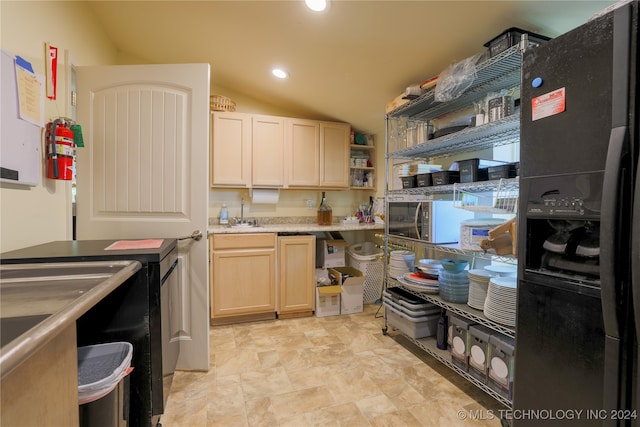 kitchen with light brown cabinets, black refrigerator with ice dispenser, lofted ceiling, and sink