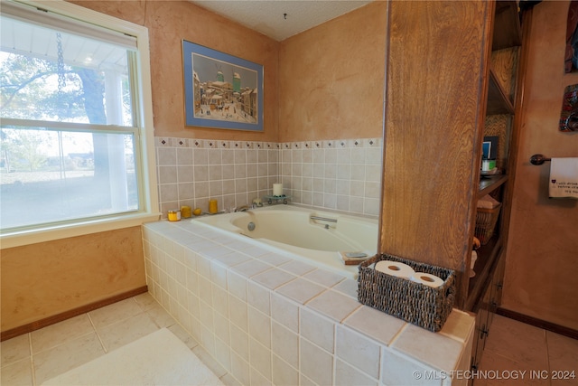 bathroom featuring tile patterned floors, tiled tub, and a wealth of natural light