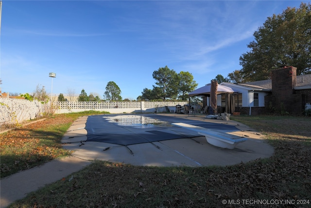 view of swimming pool with a diving board and a patio