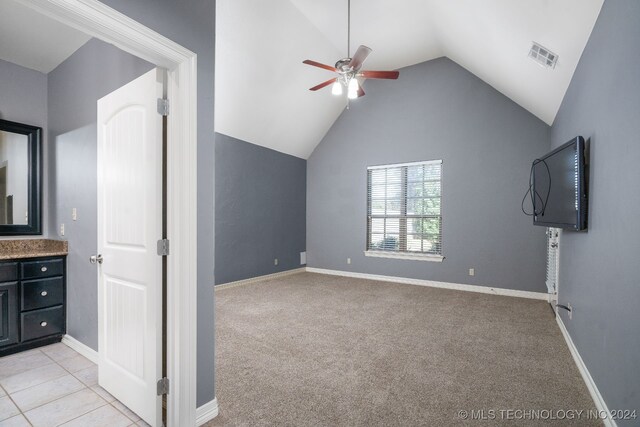 unfurnished living room with light colored carpet, vaulted ceiling, and ceiling fan