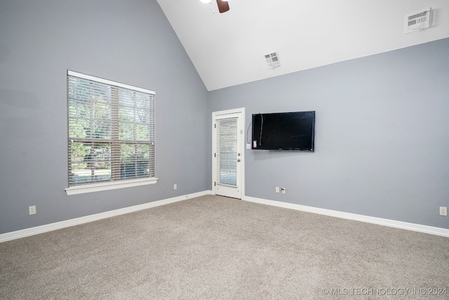 carpeted spare room featuring ceiling fan and high vaulted ceiling