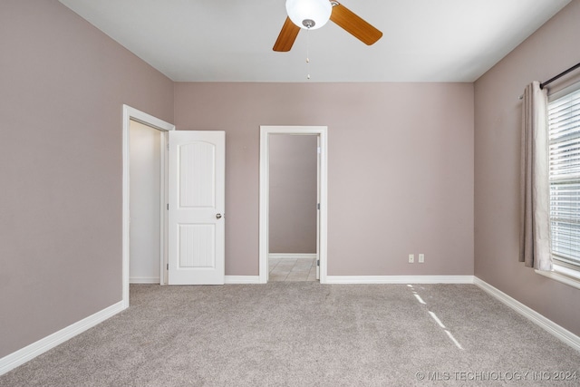 unfurnished bedroom featuring ceiling fan, a closet, and light carpet