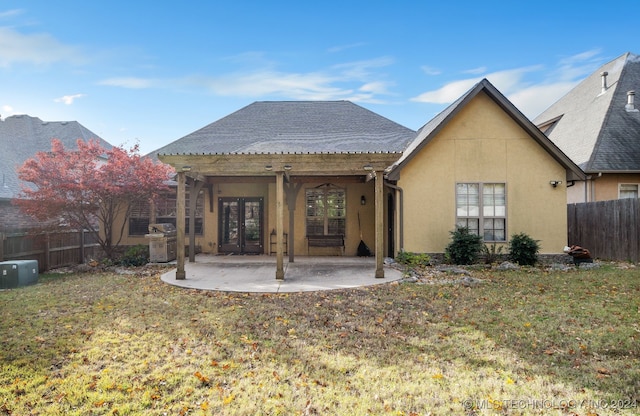 rear view of property with a lawn, a patio area, and french doors