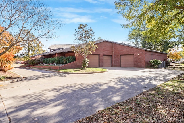 view of front of property featuring cooling unit and a garage