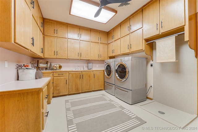 laundry area with light tile patterned flooring, cabinets, sink, and washing machine and clothes dryer