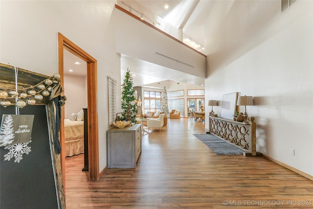 hallway featuring wood-type flooring and high vaulted ceiling