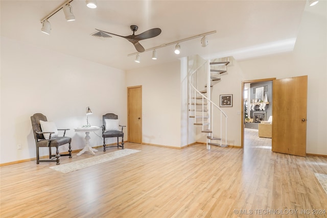 living area with track lighting, light hardwood / wood-style flooring, and ceiling fan