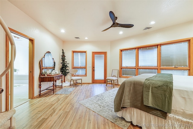 bedroom with light wood-type flooring, ceiling fan, and connected bathroom