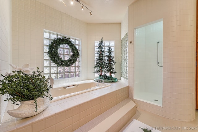 bathroom featuring tile patterned flooring and separate shower and tub