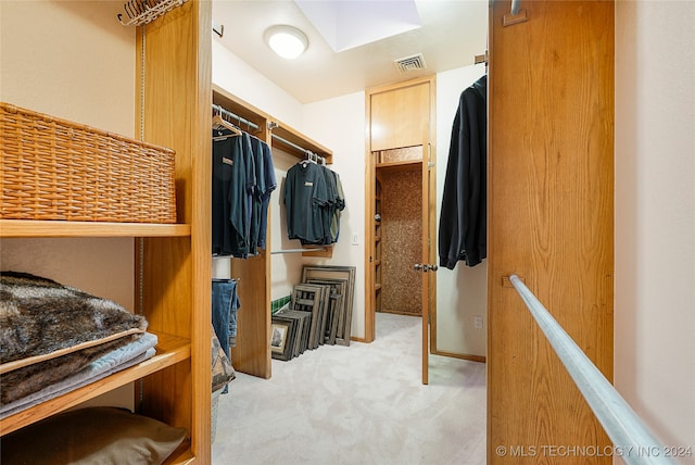 walk in closet featuring light carpet