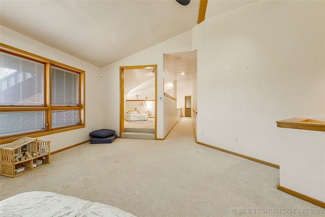 spare room with carpet and vaulted ceiling