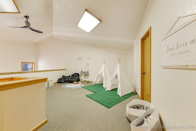 rec room featuring carpet flooring, ceiling fan, and vaulted ceiling