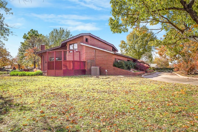 view of home's exterior featuring a lawn and central AC