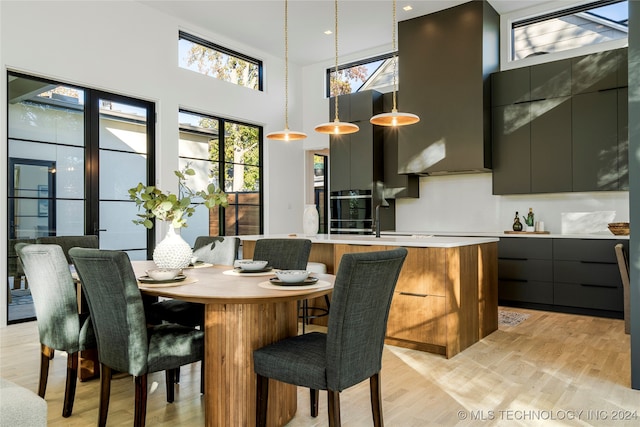 dining area with a high ceiling and light wood-type flooring