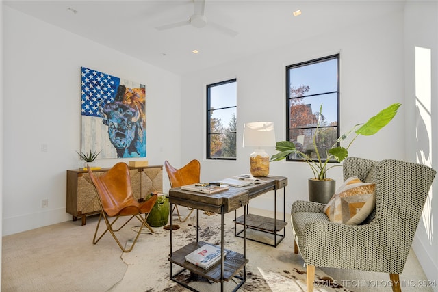 living area with ceiling fan and light carpet