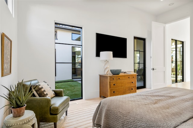 bedroom with light colored carpet and access to outside