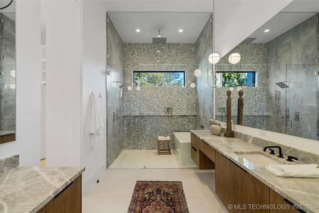 bathroom featuring tile patterned floors, vanity, walk in shower, and a wealth of natural light