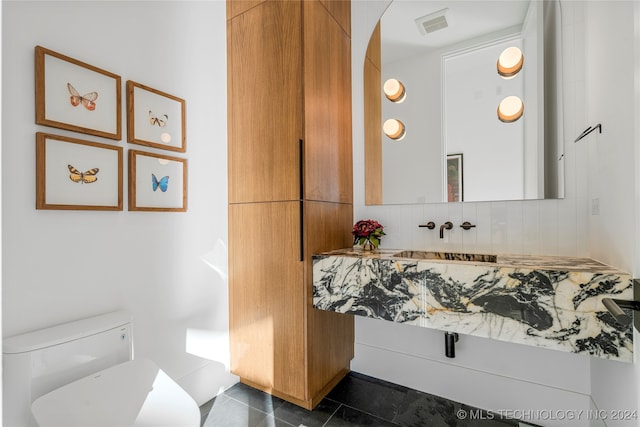 bathroom with tile patterned flooring, vanity, toilet, and backsplash